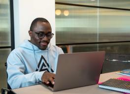 A man sitting at a desk working on a laptop