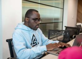 A man sitting at a desk working on a laptop