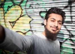 A young man taking a selfie and smiling
