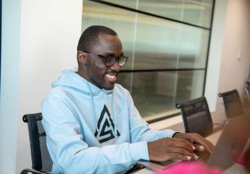 A man sitting at a desk working on a laptop