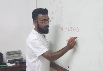 A man writing on a whiteboard
