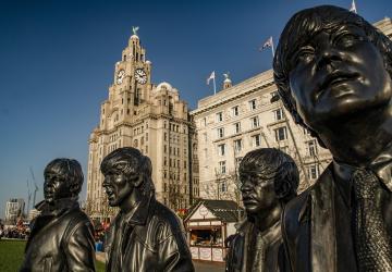 Statues of the Beatles with a backdrop of the Liver Building in Liverpool