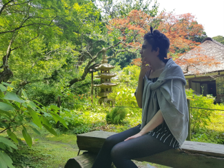 A person sitting on a bench in a Japanese garden