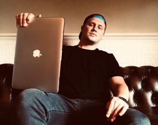  A man sitting on a sofa with a laptop on his leg