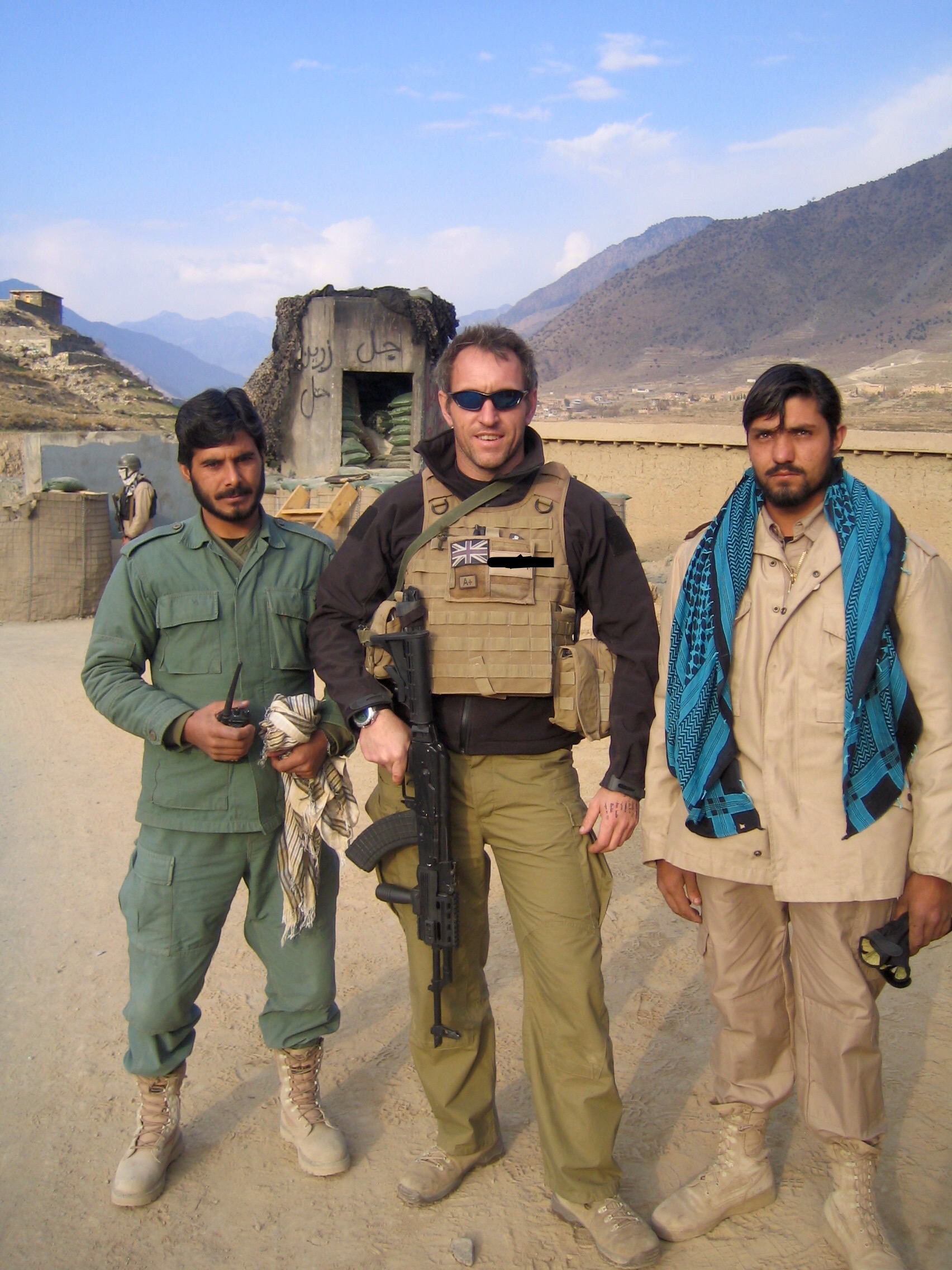 Ian in uniform with local military officers in Aghanistan
